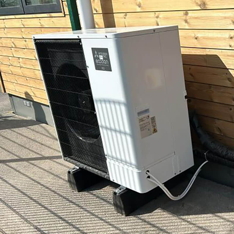 Mitsubishi air source heat pump installation situated on wooden deck beside a residential property in Beverley