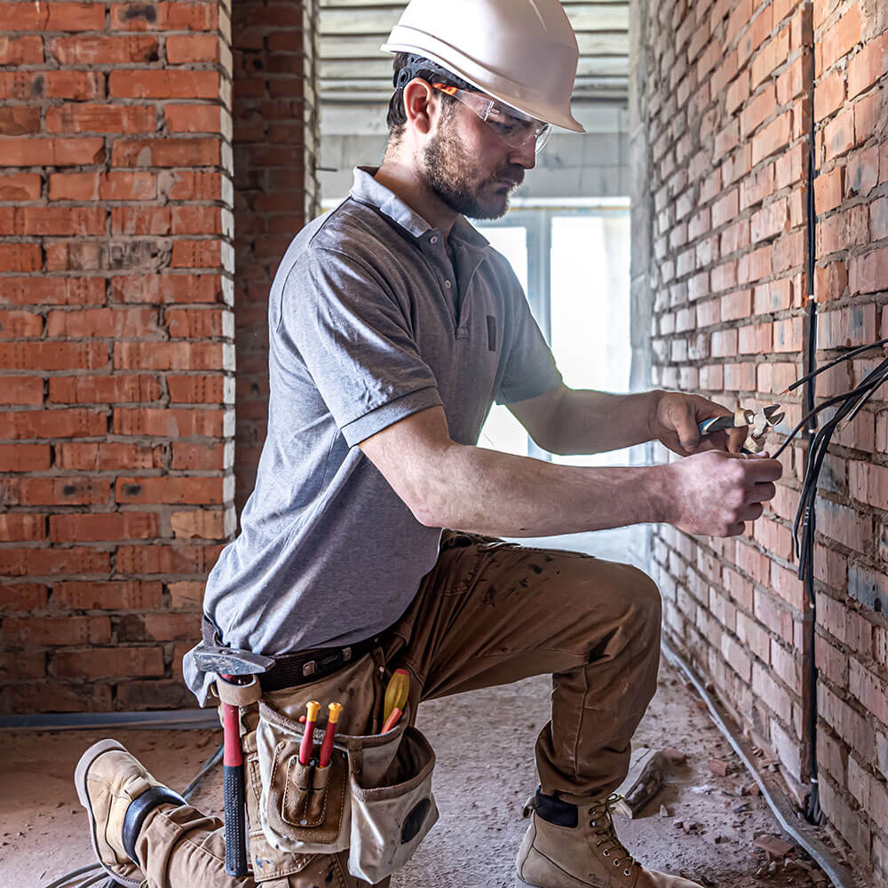 male electrician installing consumer board wiring for domestic electrical work