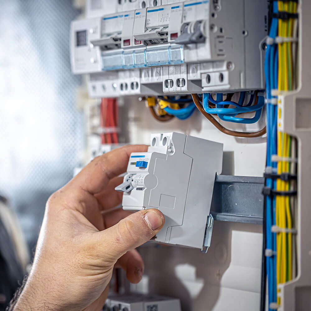 male electrician installing consumer board wiring for domestic electrical work